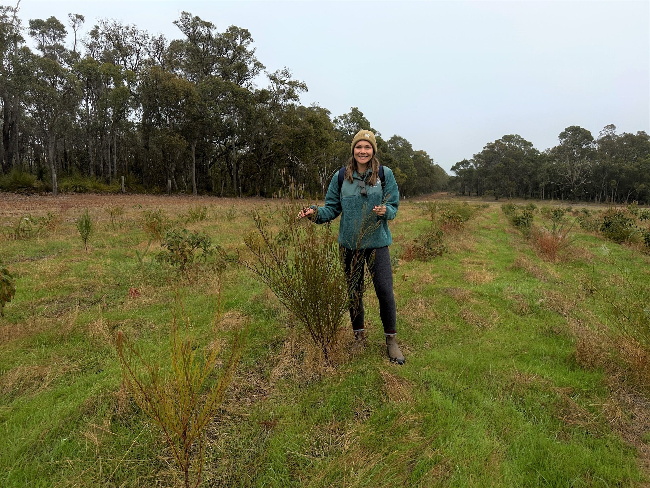 Woman standing next to small tree