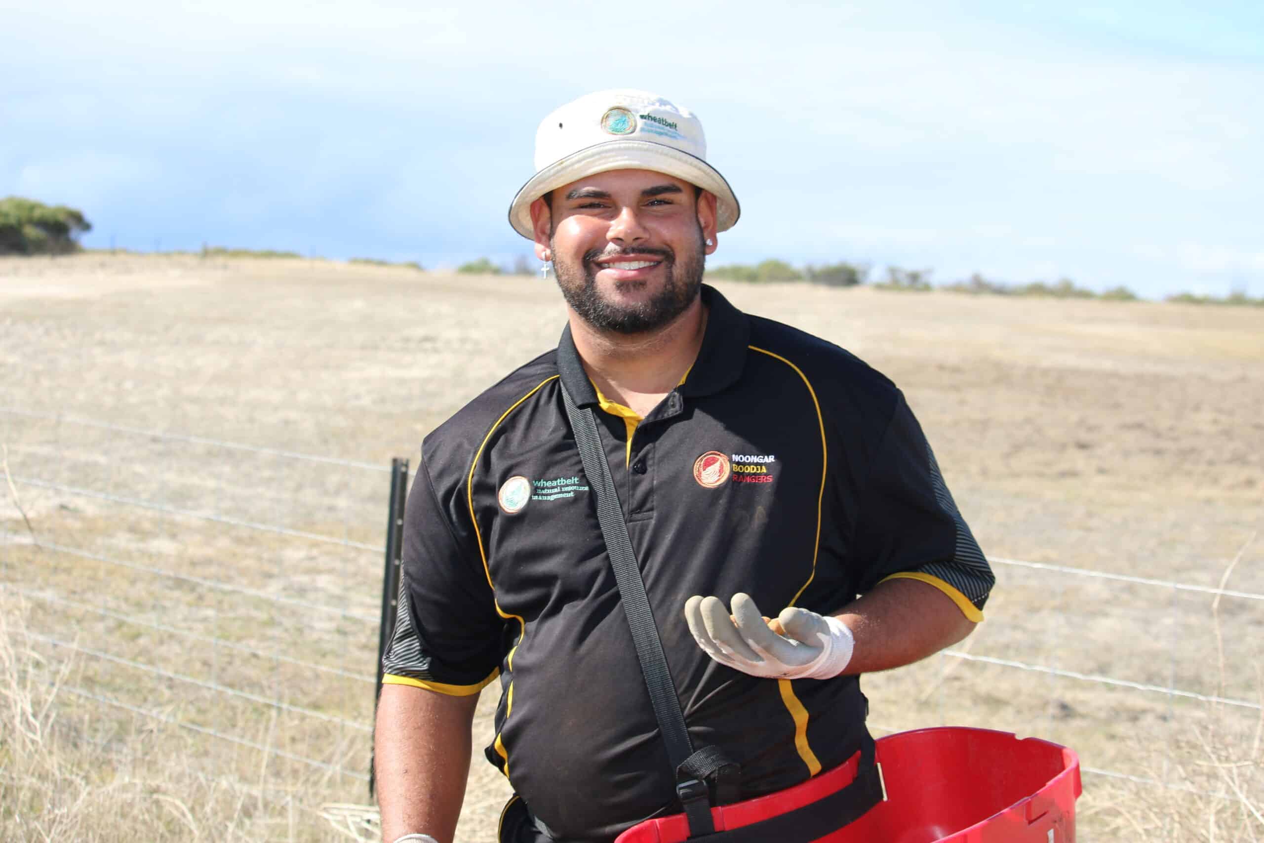 Man smiling with seedling bucket