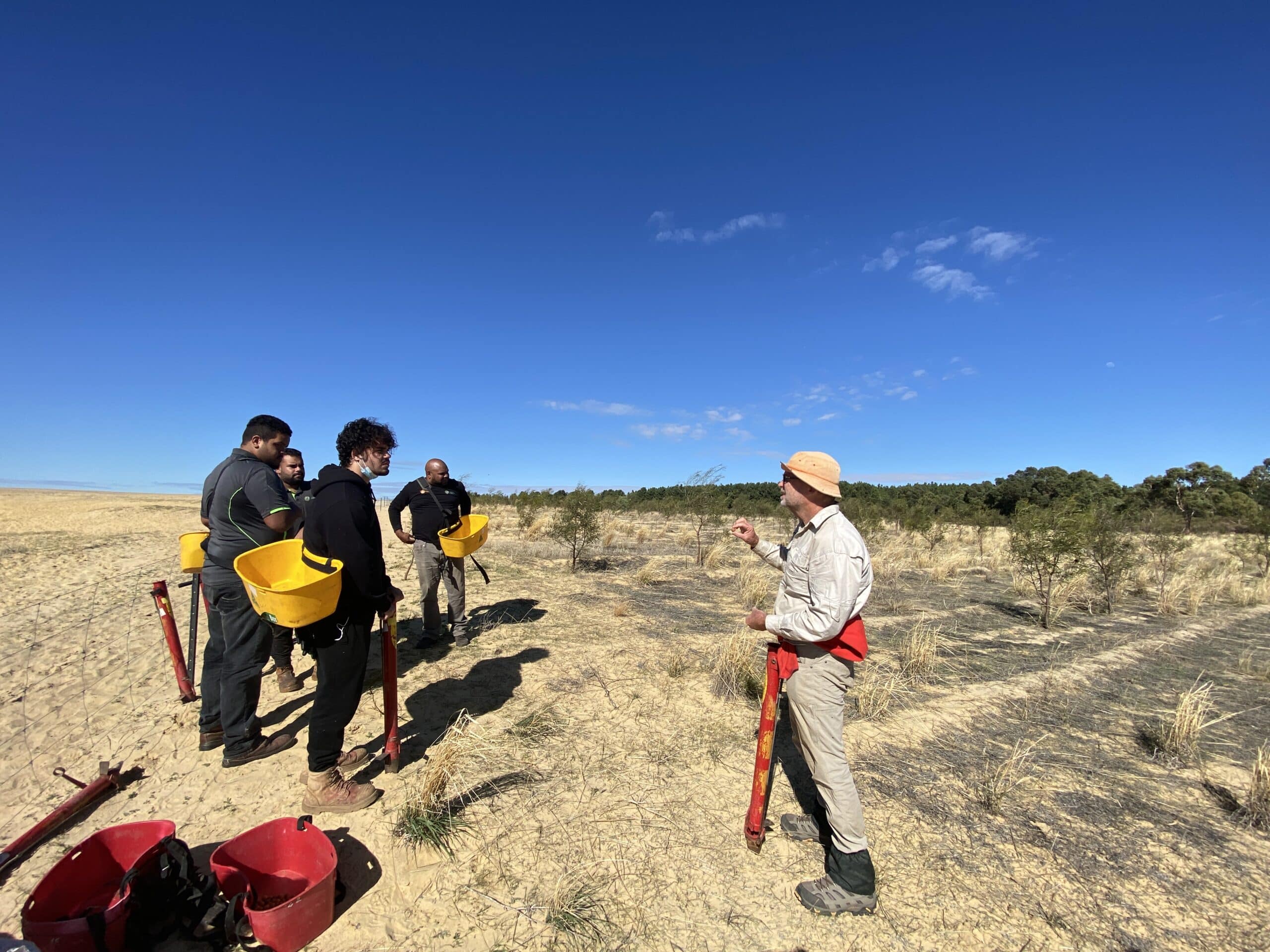 Man giving instructions to planting team with planting equipment
