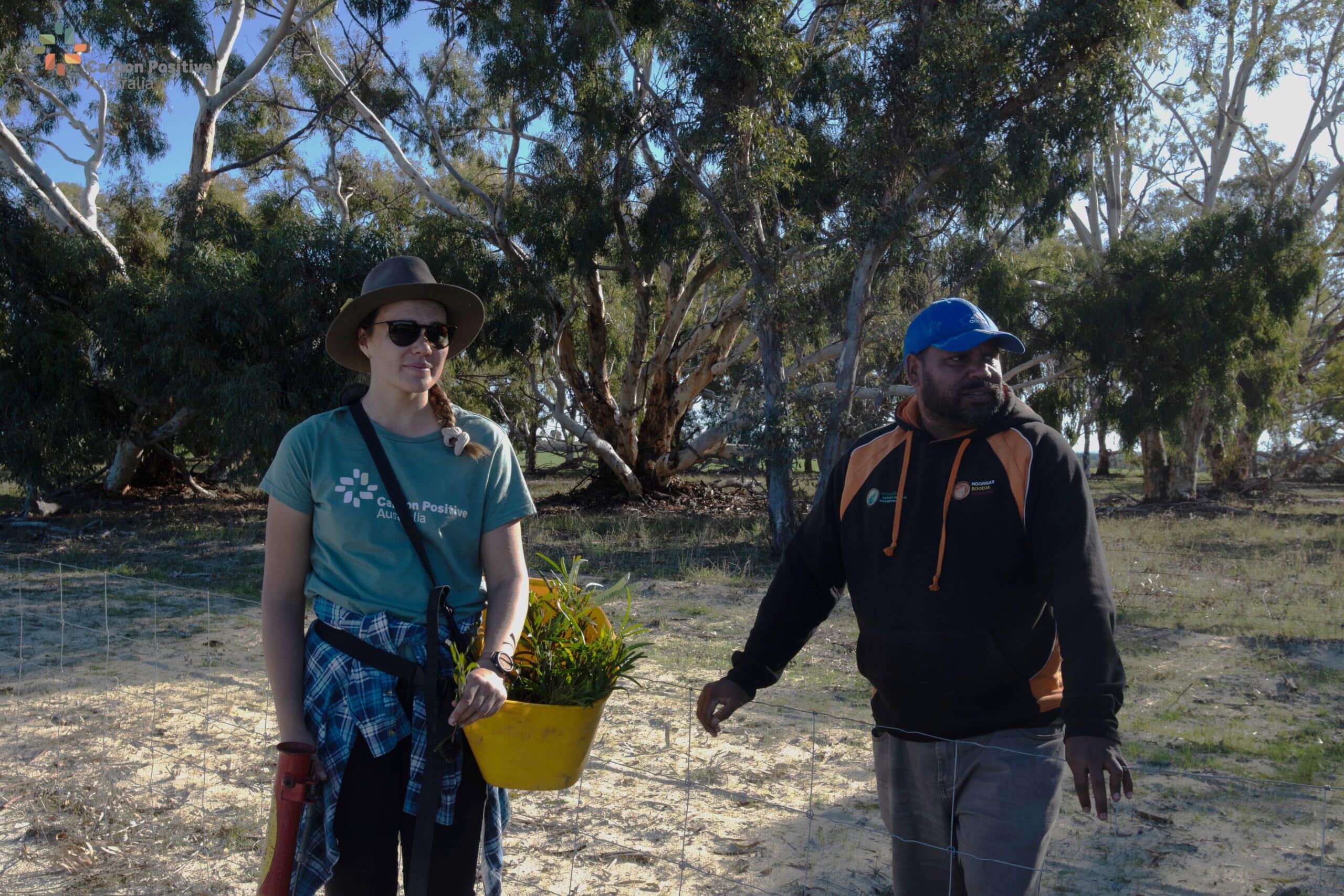 Two people standing with planting equipment