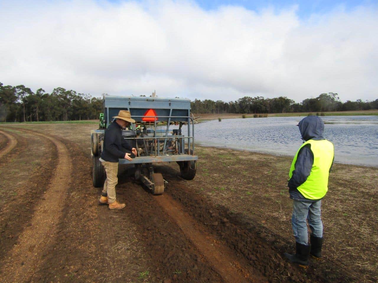 Two men inspecting planting machine