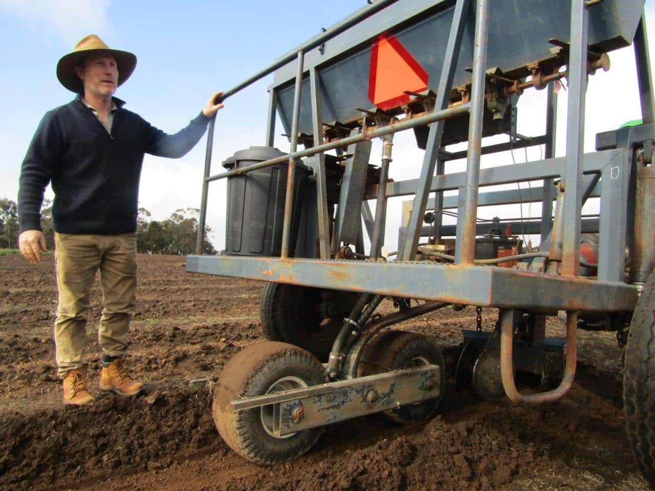 Man standing next to a direct seeding machine