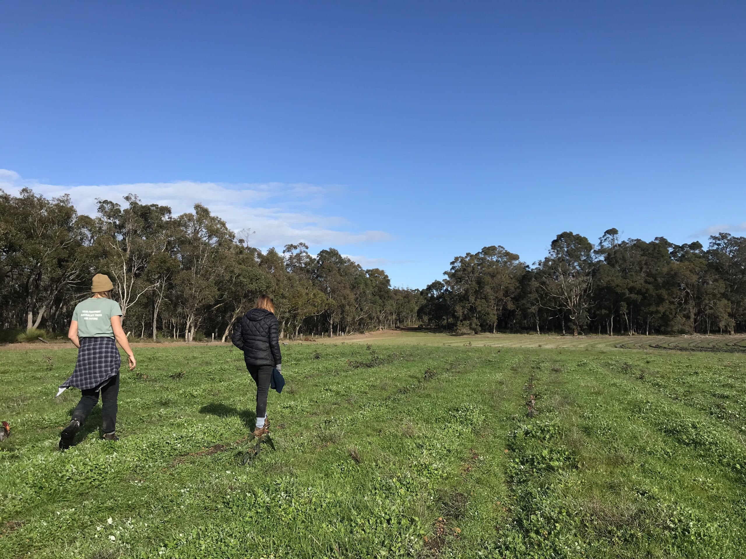 Two women walking through a planting site