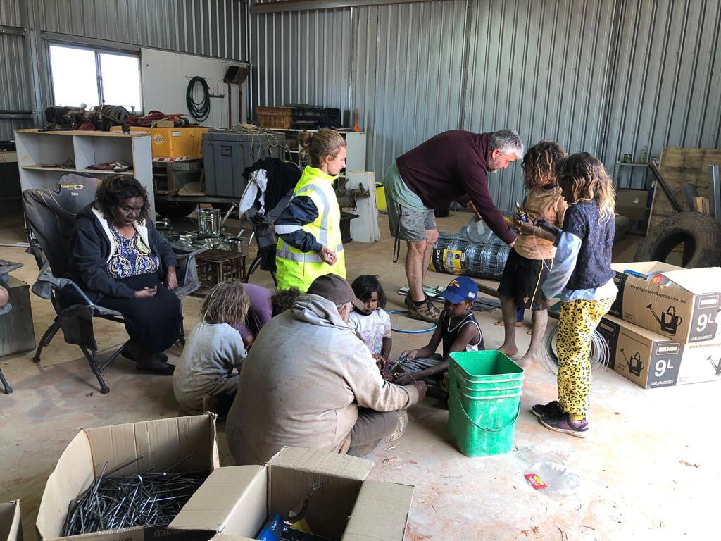 People sorting through planting supplies in a shed
