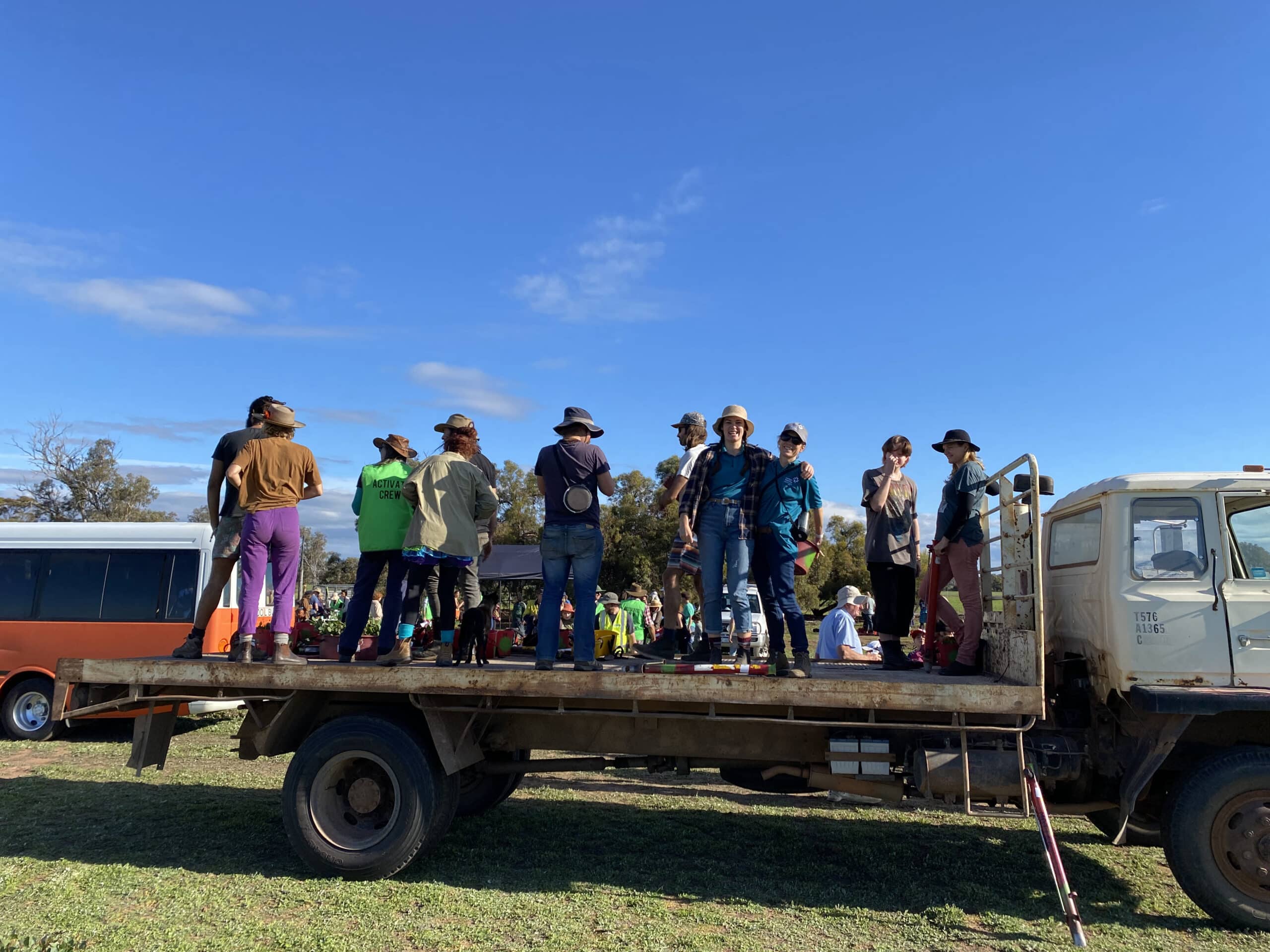 People standing on the back of a truck tray