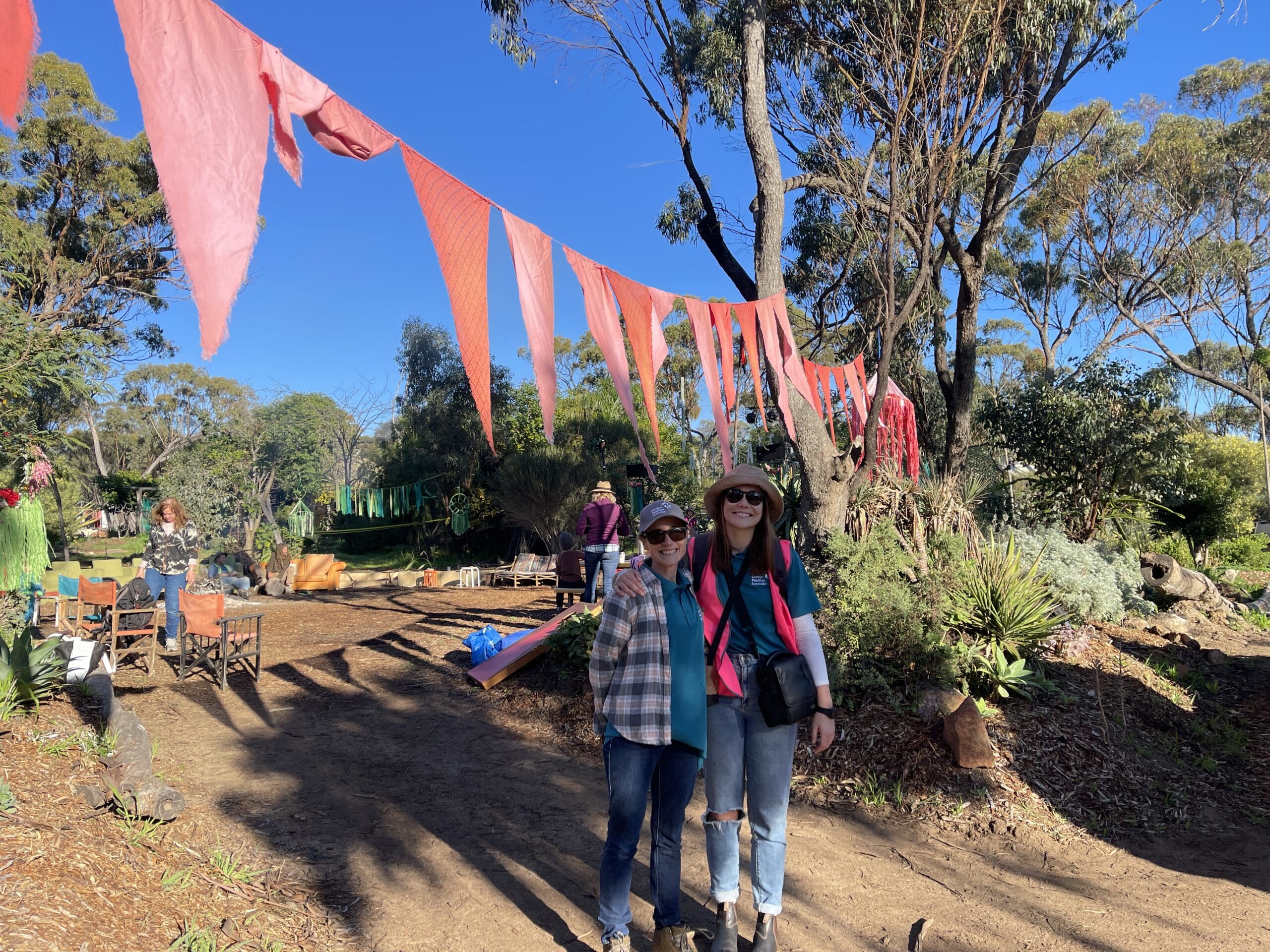 Two women standing and smiling under red bunting