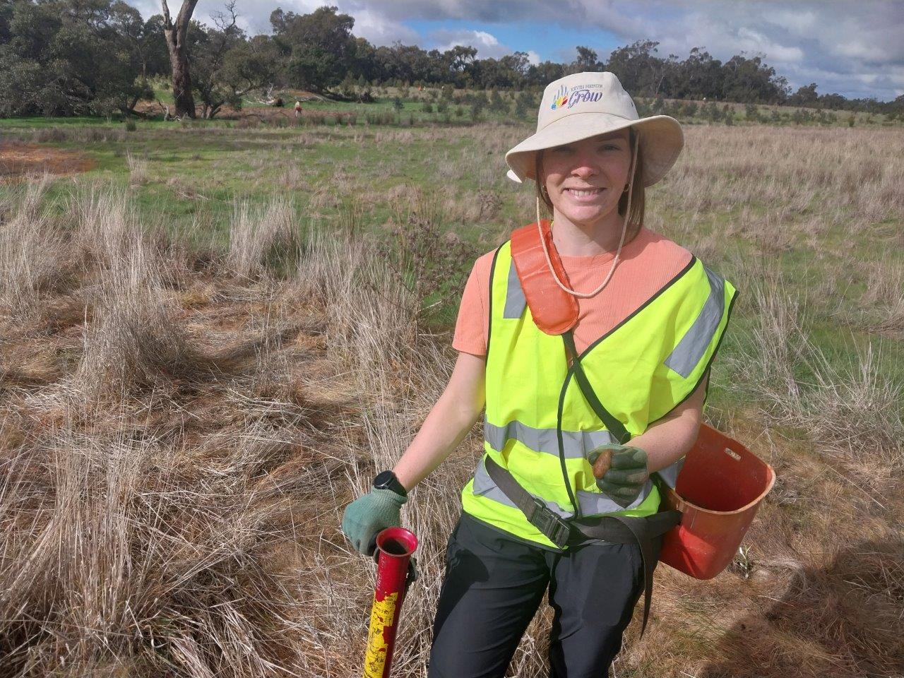 Women smiling holding a Macrozamia riedlei seed, pottiputki and bucket.