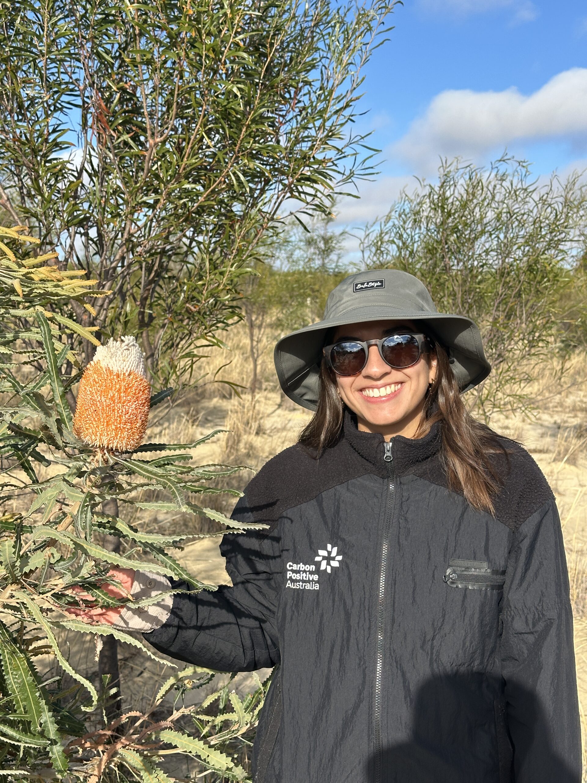 Woman standing next to a flowering banksia tree.